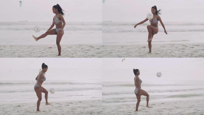4k视频片段，一个迷人的年轻女子独自在海滩上玩足球