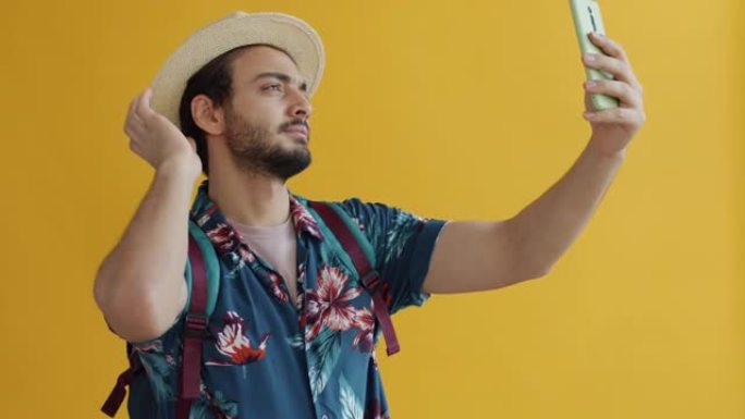 阿拉伯男子游客的慢动作肖像，背包用智能手机相机自拍