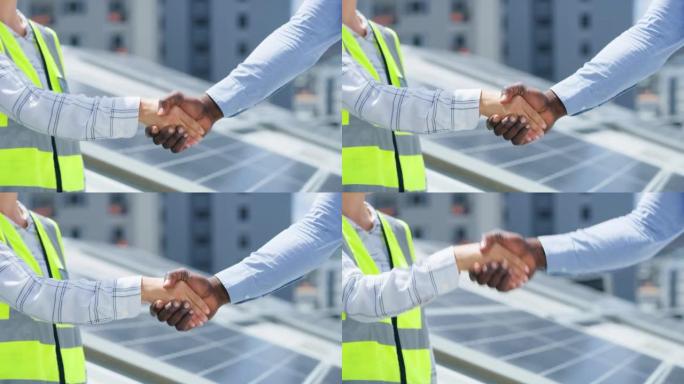 一个无法辨认的非洲裔美国男人和白人女人在安装太阳能电池板时握手问候的特写镜头。两名不同的同事为建筑和