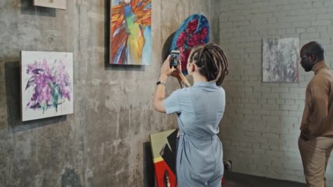为绘画拍照的女人画师画室参观油画