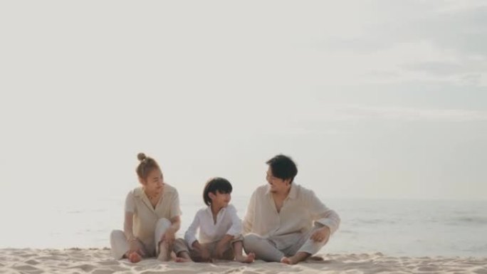 亚洲家庭与他们的儿子在海滩上度过愉快的一天