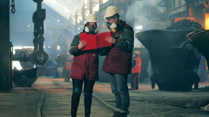 安全磨损的员工正在钢铁厂学习论文