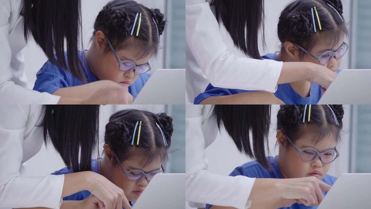 特写，老师与亚洲唐氏综合症女孩10岁女学生在小学教室里教电脑。残疾收集2019