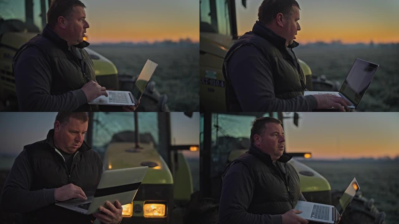 农民在日出时在寒冷的农田里在拖拉机上使用笔记本电脑