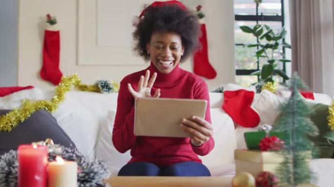快乐的非洲裔美国妇女戴着圣诞老人的帽子打视频电话