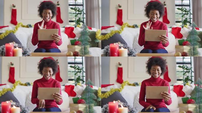 快乐的非洲裔美国妇女戴着圣诞老人的帽子打视频电话