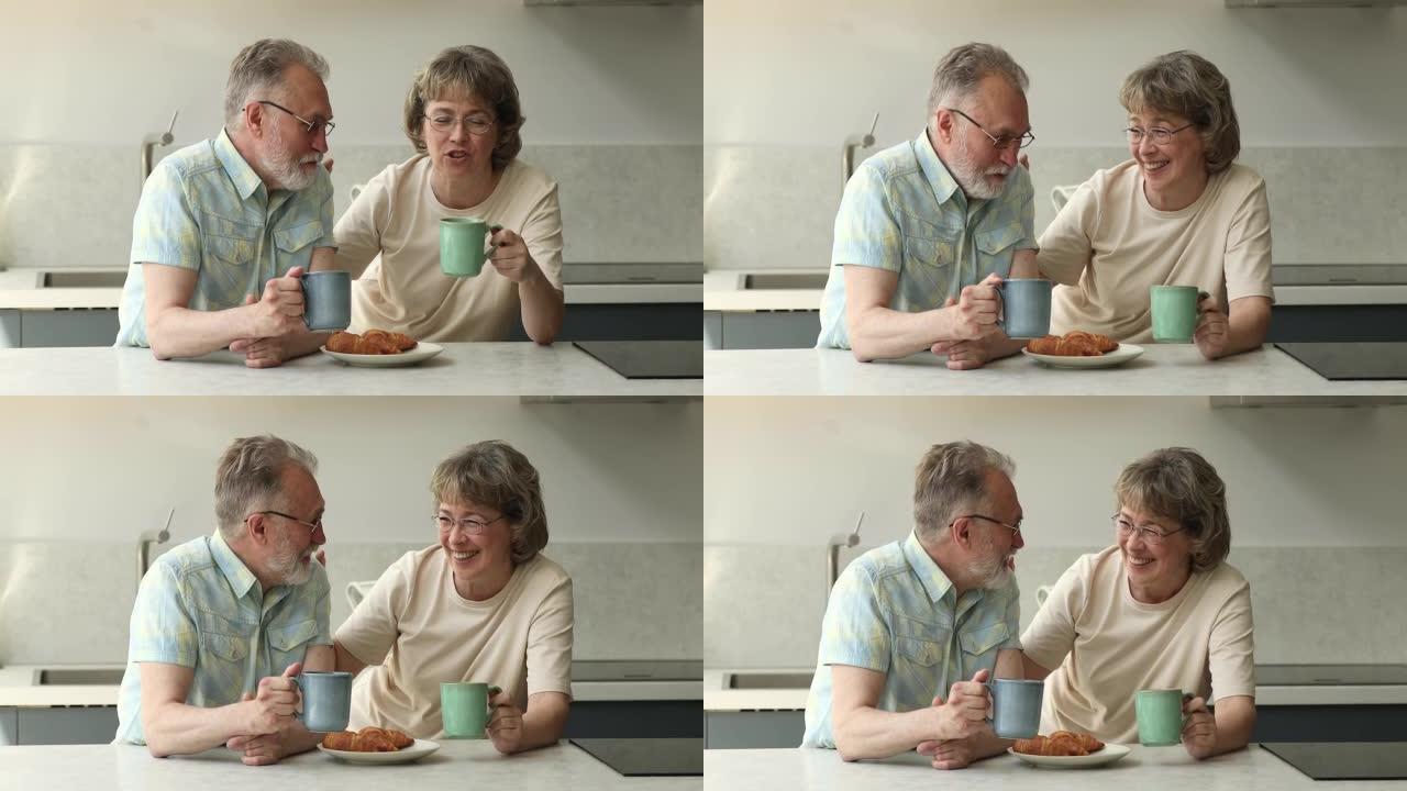 老年夫妇坐在厨房吃早餐，享受谈话