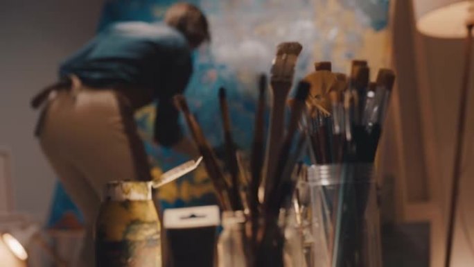 SLO MO无法识别的女艺术家在画布上用画笔绘画