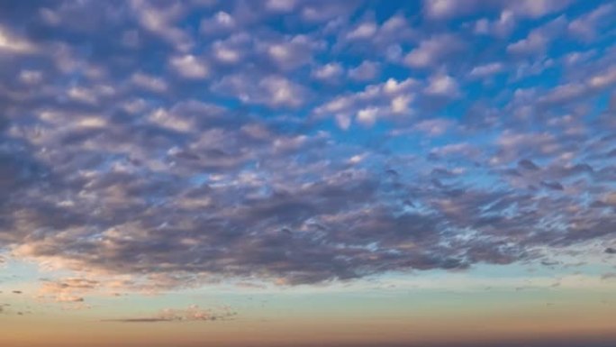 具有两个不同的圆云层的延时天空，日出时从右向左移动