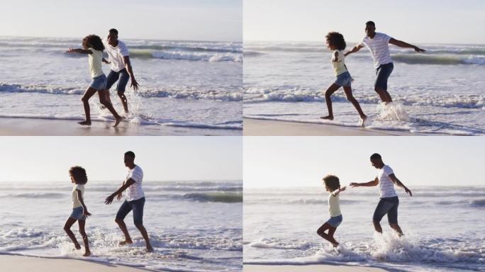 非裔美国父亲和他的女儿在海滩上玩耍