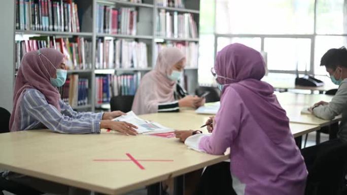 在图书馆学习的亚洲大学生观察社会距离