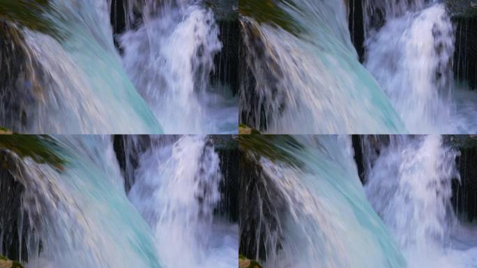特写: 野山河流过苔藓岩石，形成小瀑布