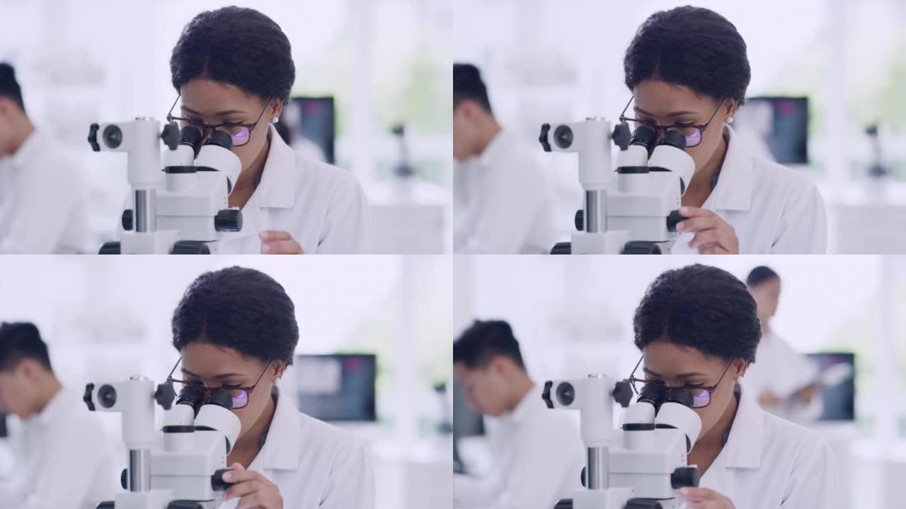 女科学家在研究实验室戴眼镜使用显微镜。年轻的生物学家或生物技术研究员使用最新的实验室技术设备工作和分