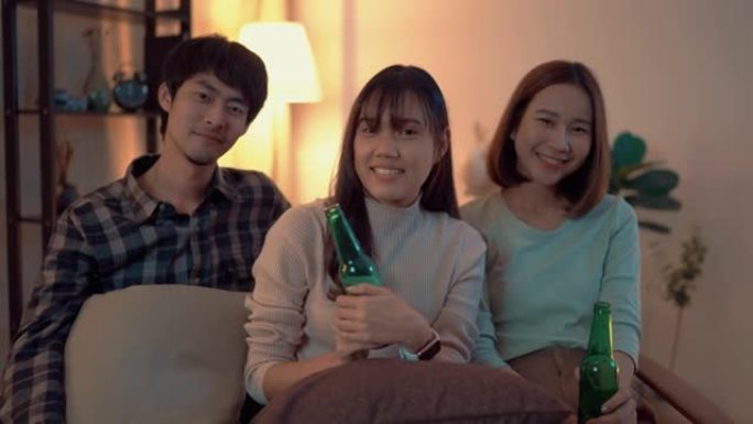 一群亚洲朋友的肖像在星期五晚上在公寓喝啤酒并一起玩乐。