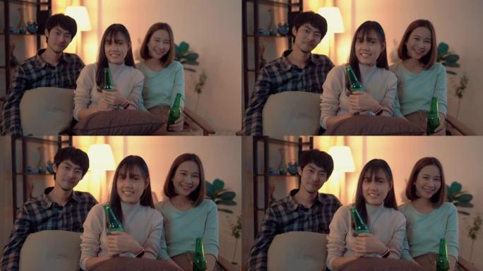 一群亚洲朋友的肖像在星期五晚上在公寓喝啤酒并一起玩乐。