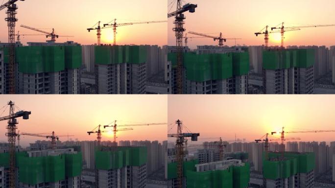日落时建筑工地起重机的鸟瞰图