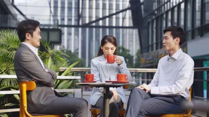 亚洲商人坐在户外咖啡店里聊天