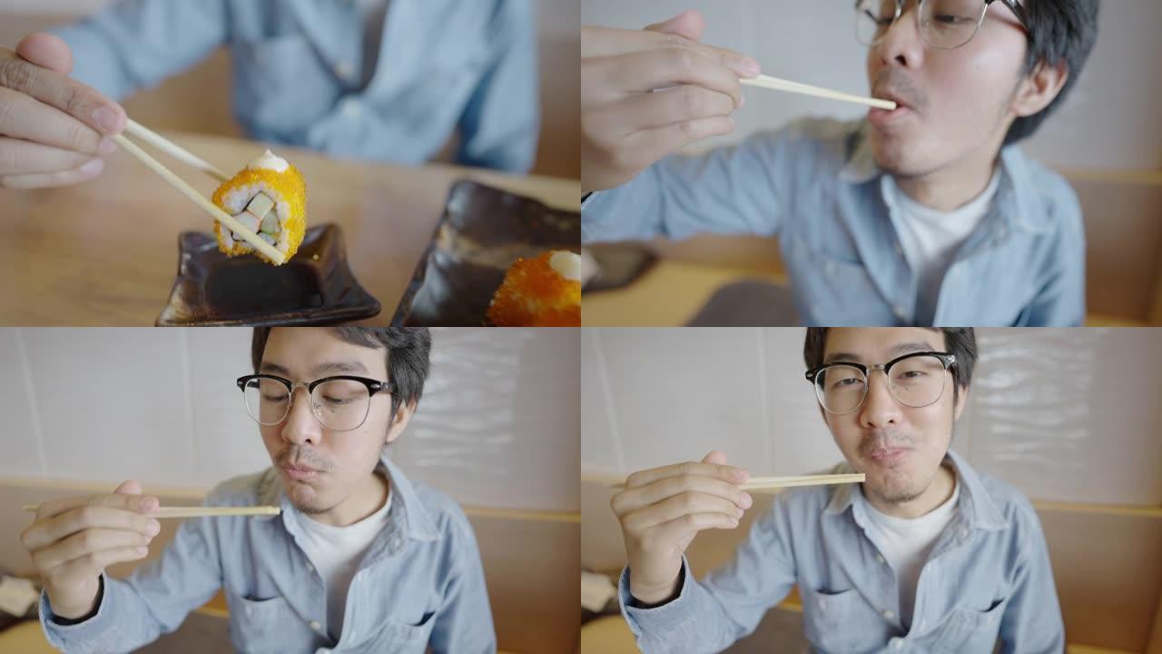 亚洲男子喜欢在日本餐厅吃寿司卷和竖起大拇指