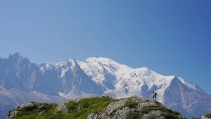 男子徒步旅行者在山上徒步旅行。勃朗峰背景