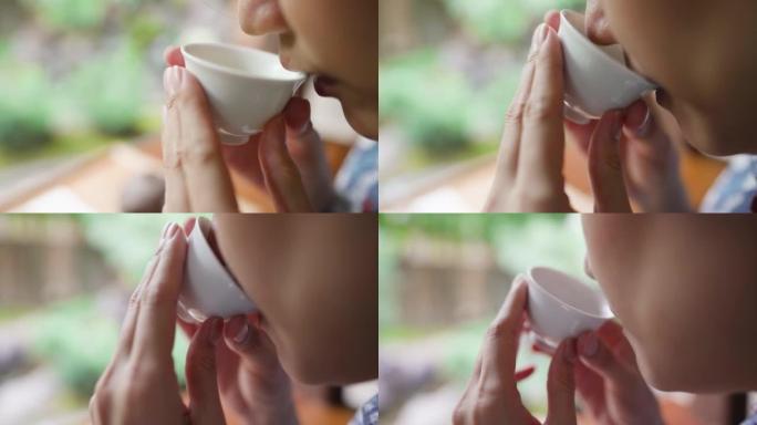 亚洲女性在花园里喝日本茶