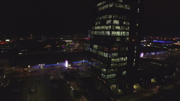 天线: 夜间在大型办公室摩天大楼工作的商人