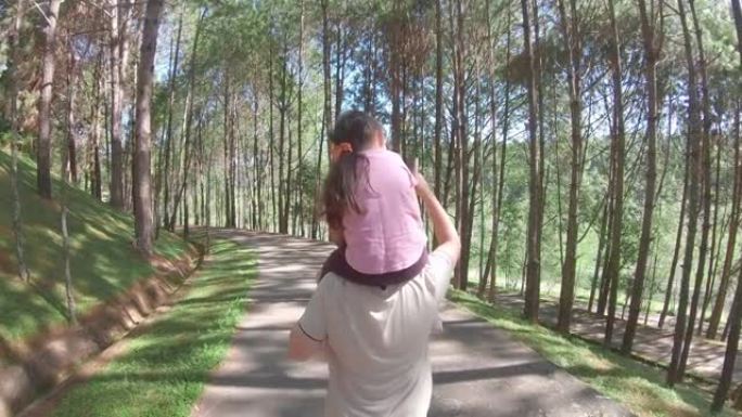 小女孩在公园里背着她的父亲