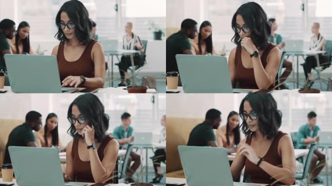 4k视频片段，一个年轻的女商人坐在办公室里，用笔记本电脑看起来很沉思