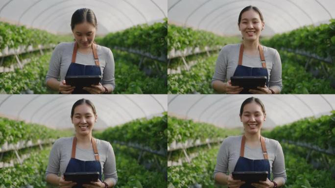 自信的亚洲妇女与数字平板电脑在温室