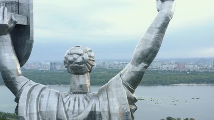 在基辅城市全景第聂伯上空，无人驾驶飞机在史诗般的祖国纪念碑雕像周围飞行，这是乌克兰自由的象征。