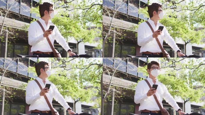 亚洲男子戴口罩与自行车在街上使用智能手机
