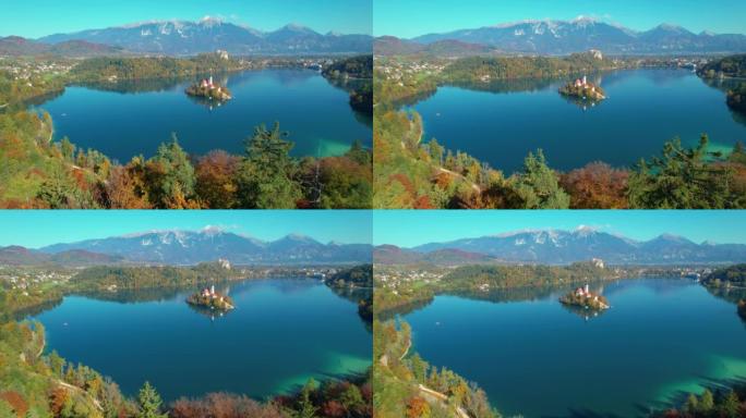 空中无人机在色彩缤纷的秋天树上飞行，可以看到布莱德湖的全景