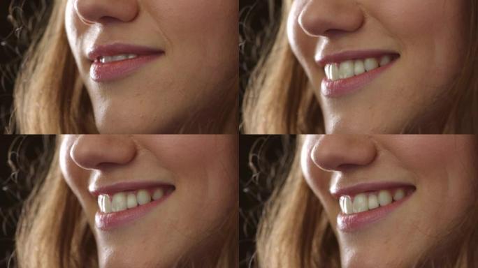 微笑女人的嘴唇和露出牙齿的特写镜头，同时穿着粉红色的口红，化妆和化妆品。爆头，脸部和嘴巴的美丽微笑细