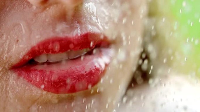 超级SLO MO水滴落在女人脸上，带有强烈红色的唇膏