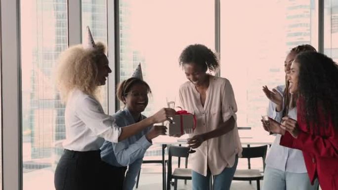 四名女同事在工作场所祝贺非洲女同事生日
