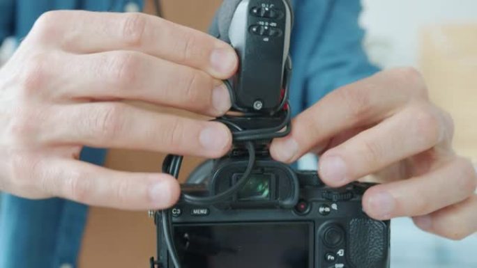博客作者准备录制视频时，用现代相机工作的男性手的特写镜头