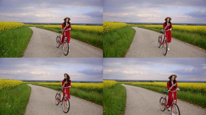 追踪一个穿着红色连衣裙的黑发女人的照片，看着她的手机，一边骑着自行车，周围是金鱼草的花朵，慢动作
