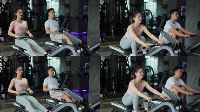 年轻男女在健身房用划船机锻炼