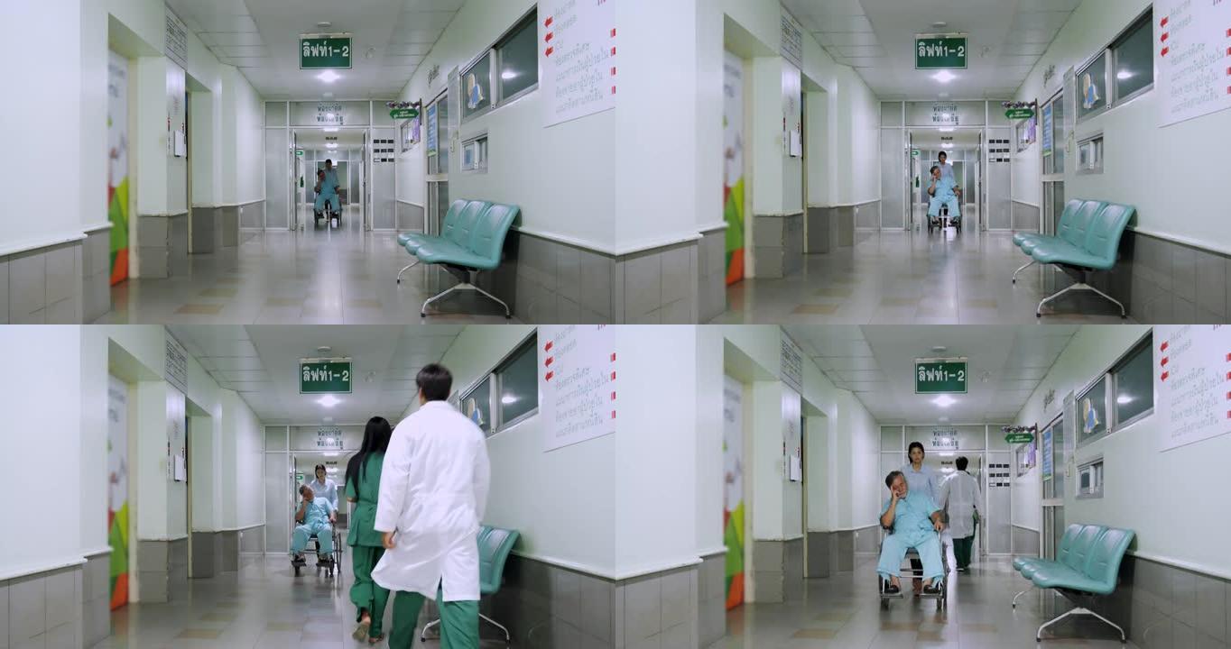 后视图，医生和护士在现代医院大楼的医院走廊中行走，而助理推动亚洲高级男性患者坐在轮椅上。医院概念。
