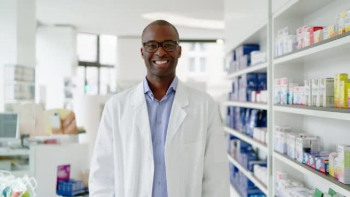 在药店站在架子上的非洲男药剂师的肖像