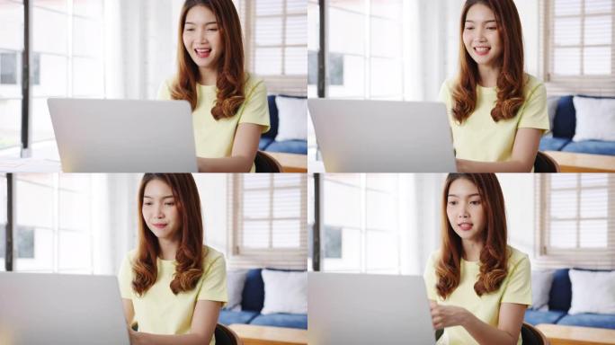 亚洲女商人使用笔记本电脑与同事谈论视频通话中的计划，同时在客厅在家中智能工作。
