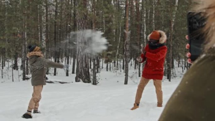 男人和男孩玩雪球打雪仗除雪人物