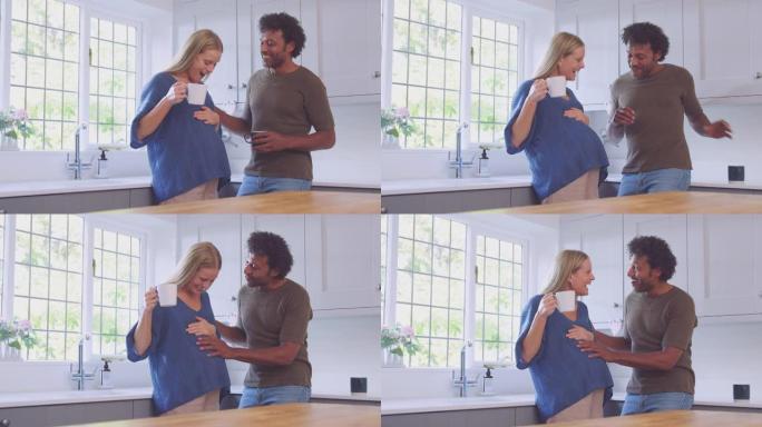 成熟的夫妇和怀孕的妻子在厨房一起聊天和喝咖啡