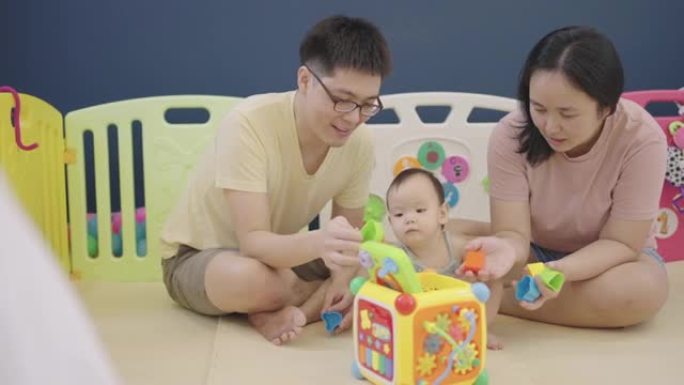 亚洲父母在女儿玩玩具时照顾她