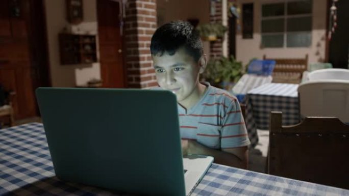 在农村家庭中使用笔记本电脑在线学习的小男孩