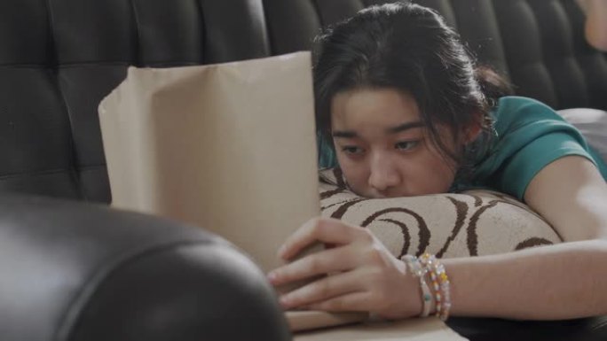 特写亚洲少年女孩在家时读一本非小说类书籍。她翻开学习书的一页。学习绿色教育的女孩。