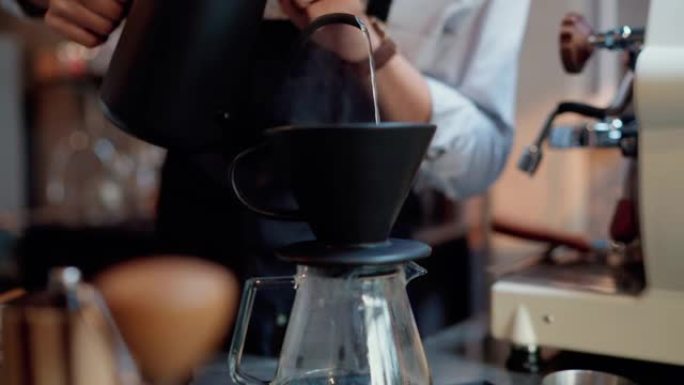咖啡师将热水倒在接地的咖啡上。