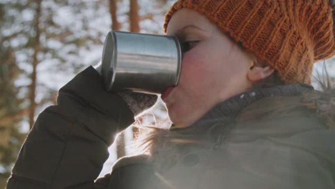 小女孩在冬天徒步旅行时喝热茶