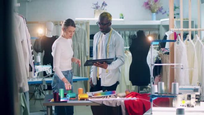 非洲裁缝正在车间向裁缝展示工具