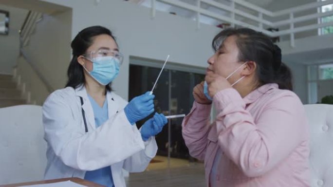 亚洲女护士戴口罩给住院女病人做covid拭子测试