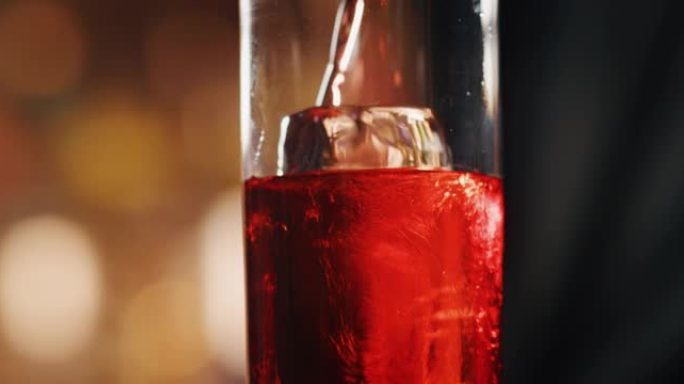 专业调酒师的特写镜头正在为酒吧或迪斯科俱乐部的顾客准备一杯带有专业水晶持久冰块的长饮鸡尾酒。
